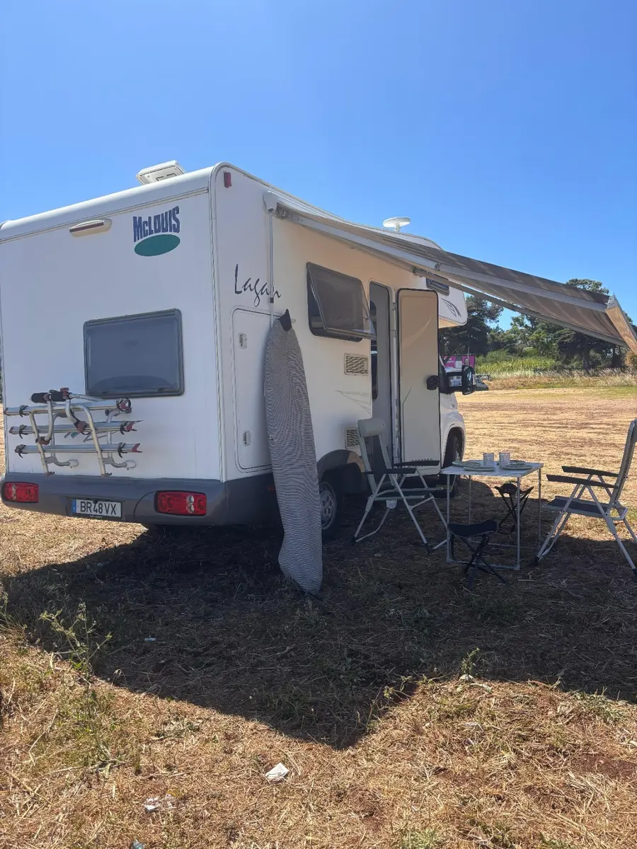 Concha Caravan with awning, outdoor table and surfboard